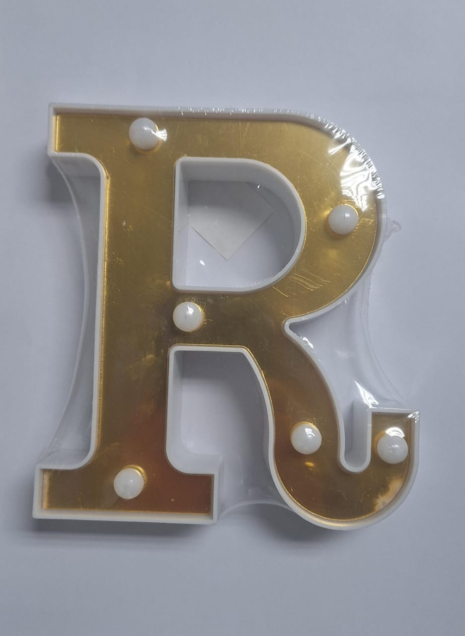 Gold and white decorative letters that light up, spelling out a message, from ET, displayed on a clean surface.