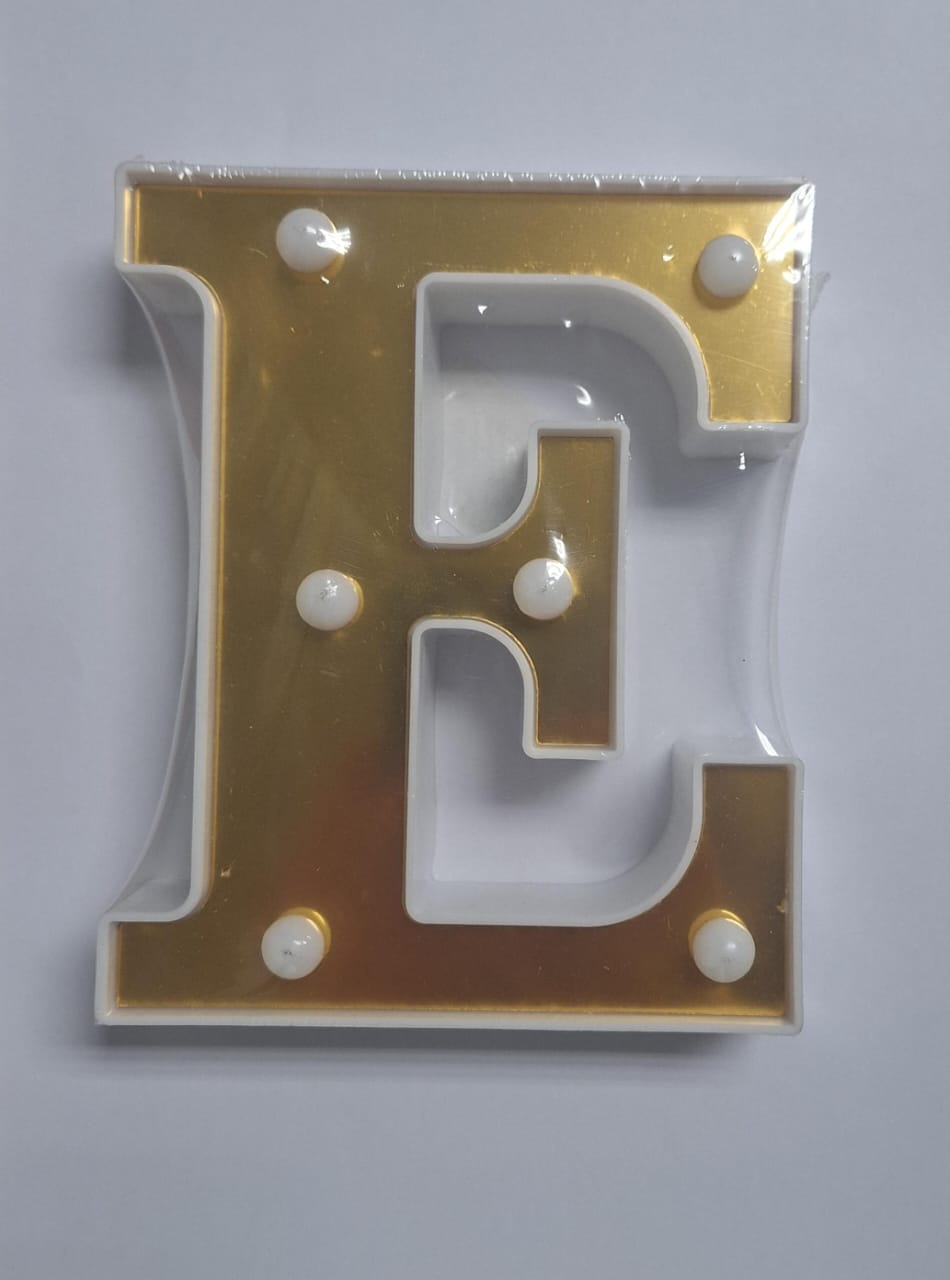 Gold and white decorative letters that light up, arranged on a surface, displaying the ET brand logo in a stylish display.