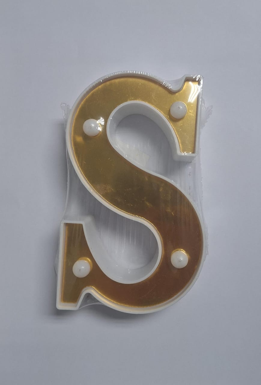 Gold and white decorative letters that light up, arranged on a surface, from the ET brand.