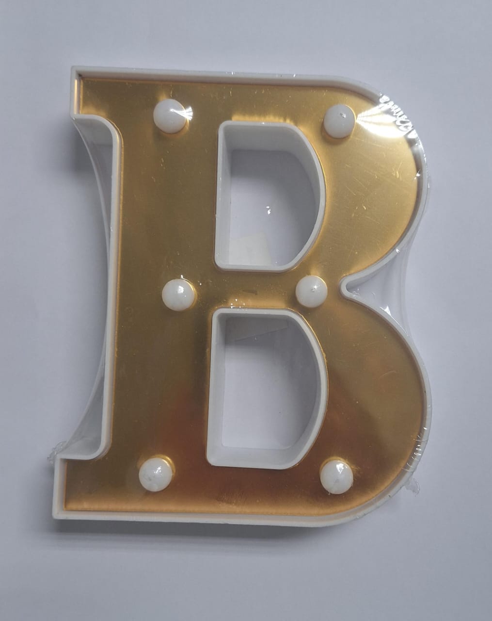 Gold and white decorative letters that light up, spelling out a word, from ET, displayed on a plain background.